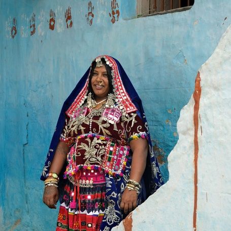 Lambadi woman in vibrant traditional attire with jewelry.