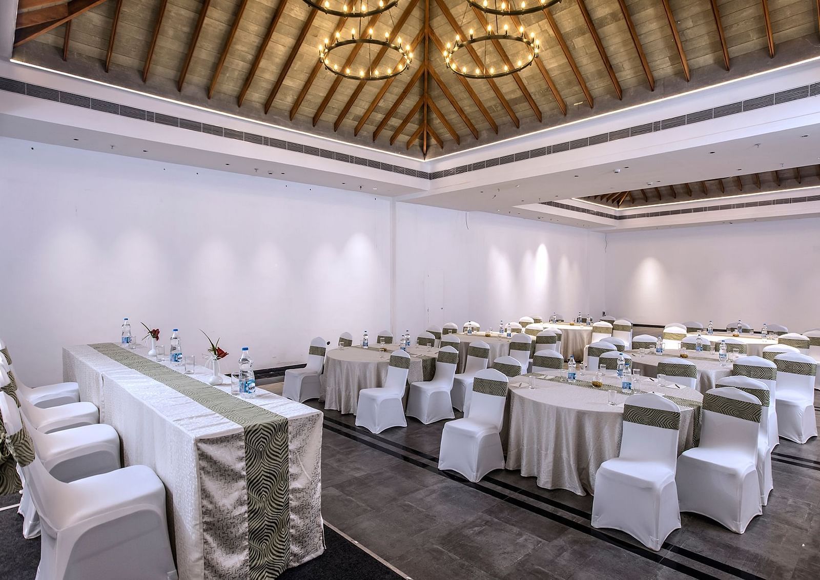 Another angle of the banquet hall with round tables and chairs | Great Trails Wayanad by  GRT hotels.