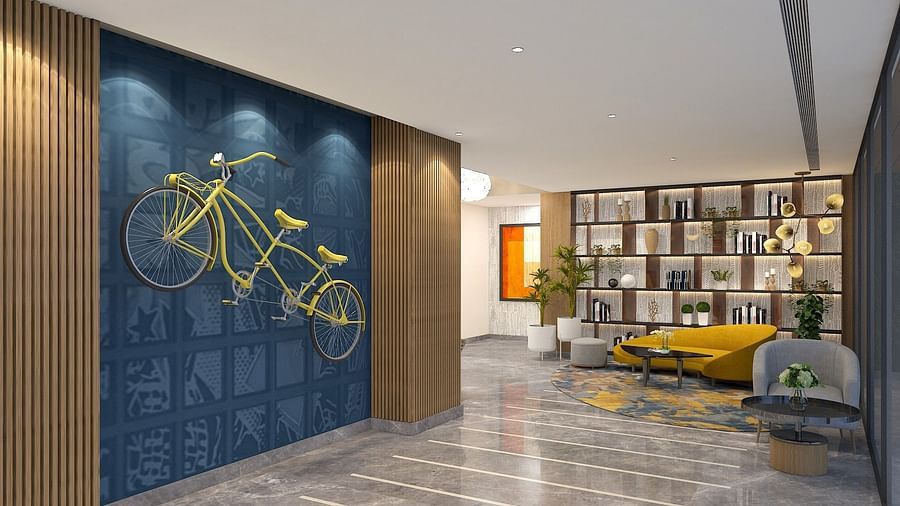 A bicycle on a wall with sofas in the background - Golden Tulip Bhopal