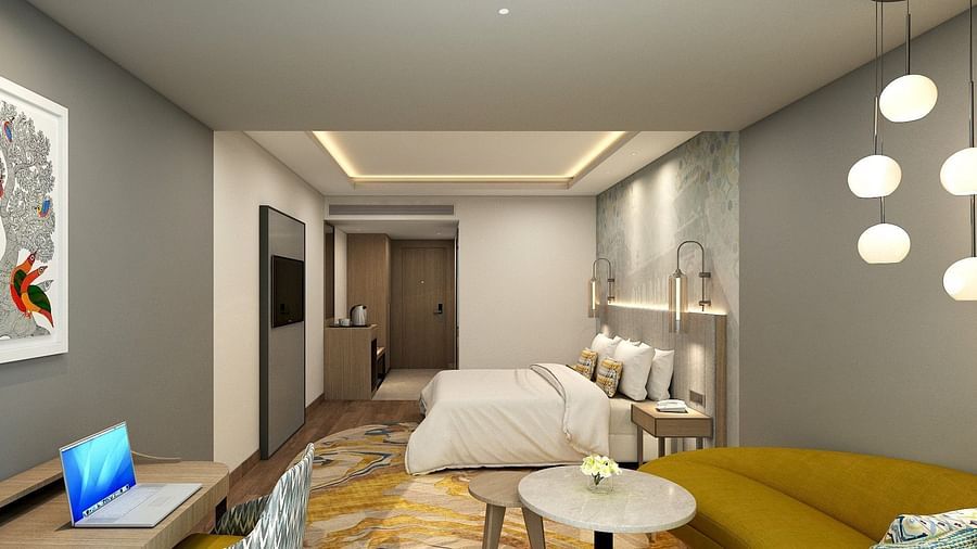 sofa and work desk in the foreground and a double bed in the background - Golden Tulip Bhopal