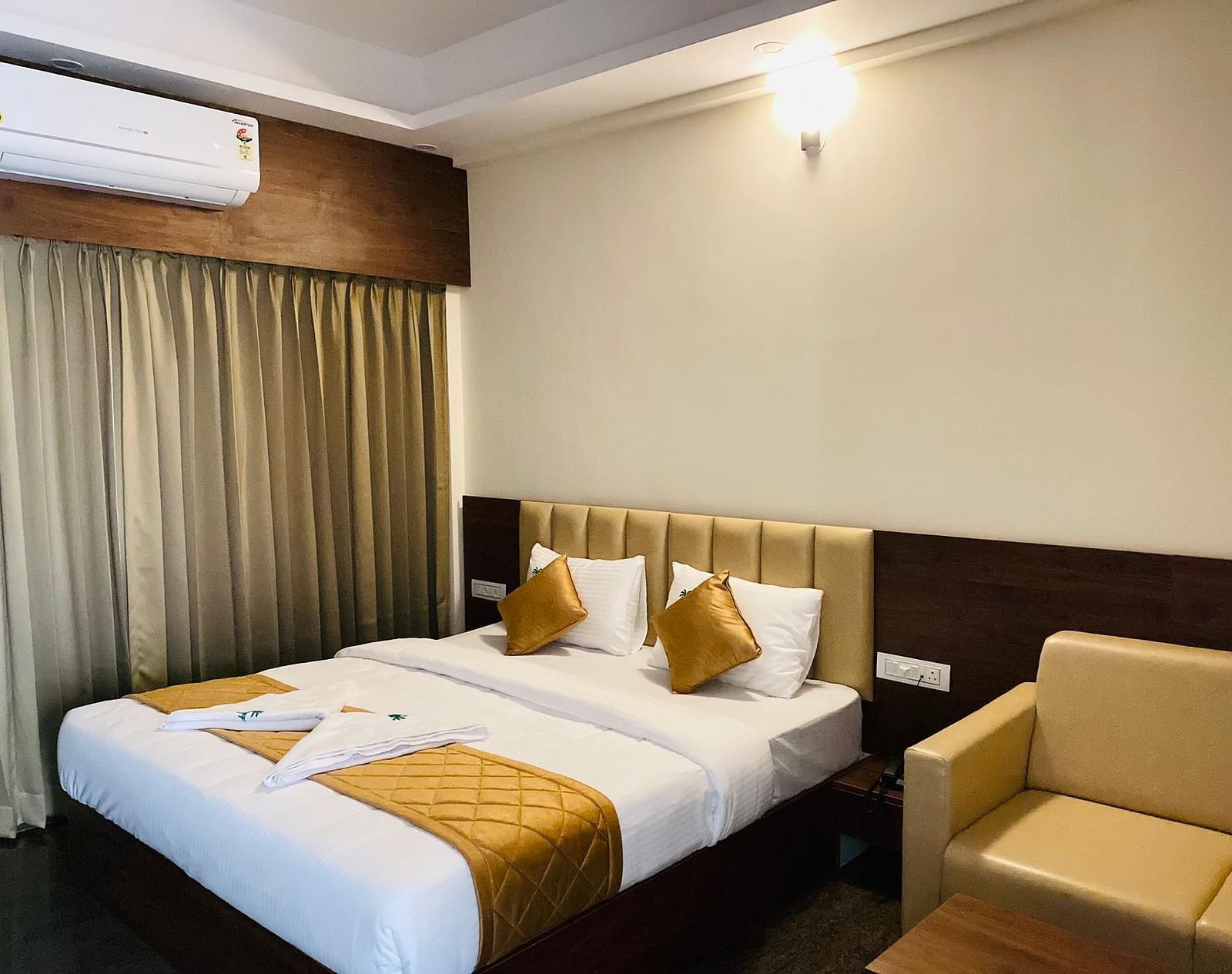 Room featuring twin beds, golden pillows, and stylish drapery for a restful stay at Hotel Sahara Tree.
