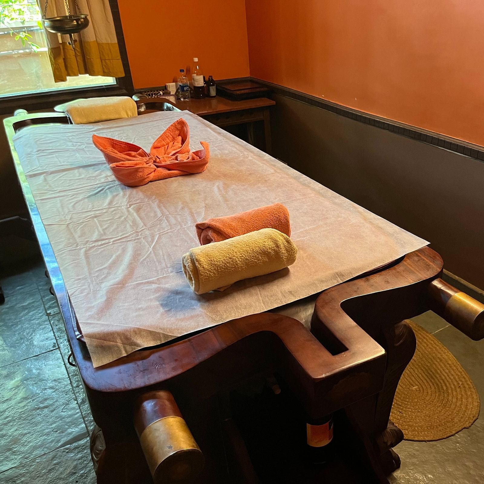 image of the bed at the Ayurveda spa with decorated towels on it at hoysala village resort in hassan