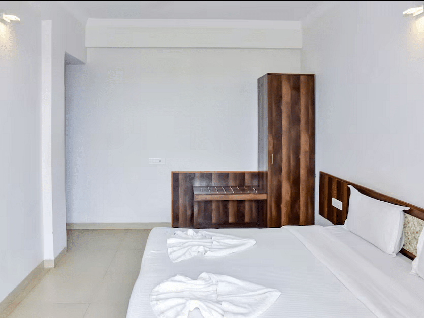 A  spacious room with a bed and wardrobe at La Vida Studio Inn Goa.