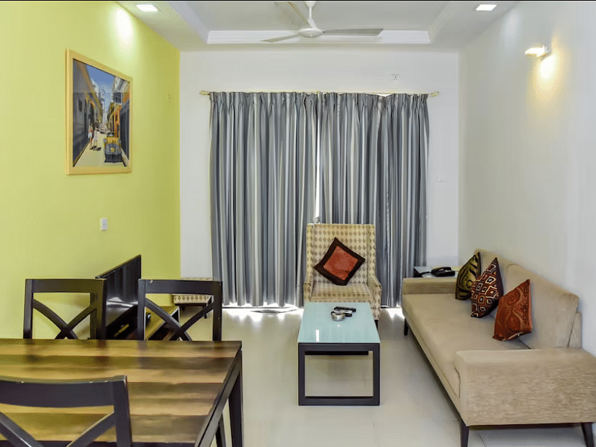 Living and dining space with a sofa and table at La Vida Studio Inn Goa.