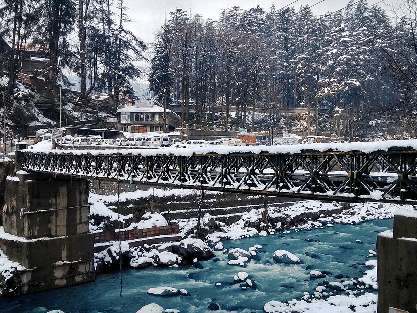 A snow-covered bridge with a river flowing underneath