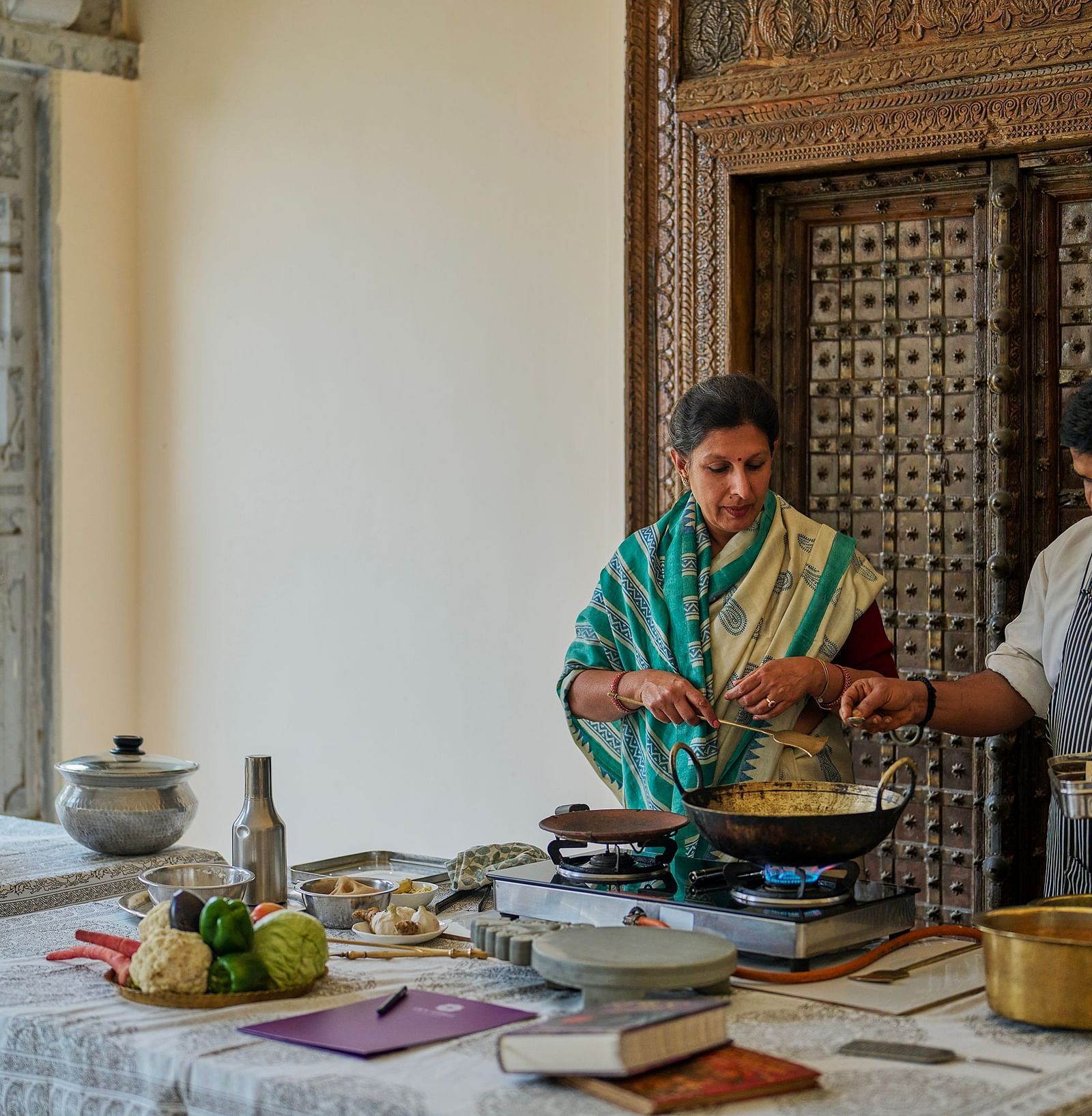 image featuring a woman cooking along with a chef supervising at dev shree deogarh