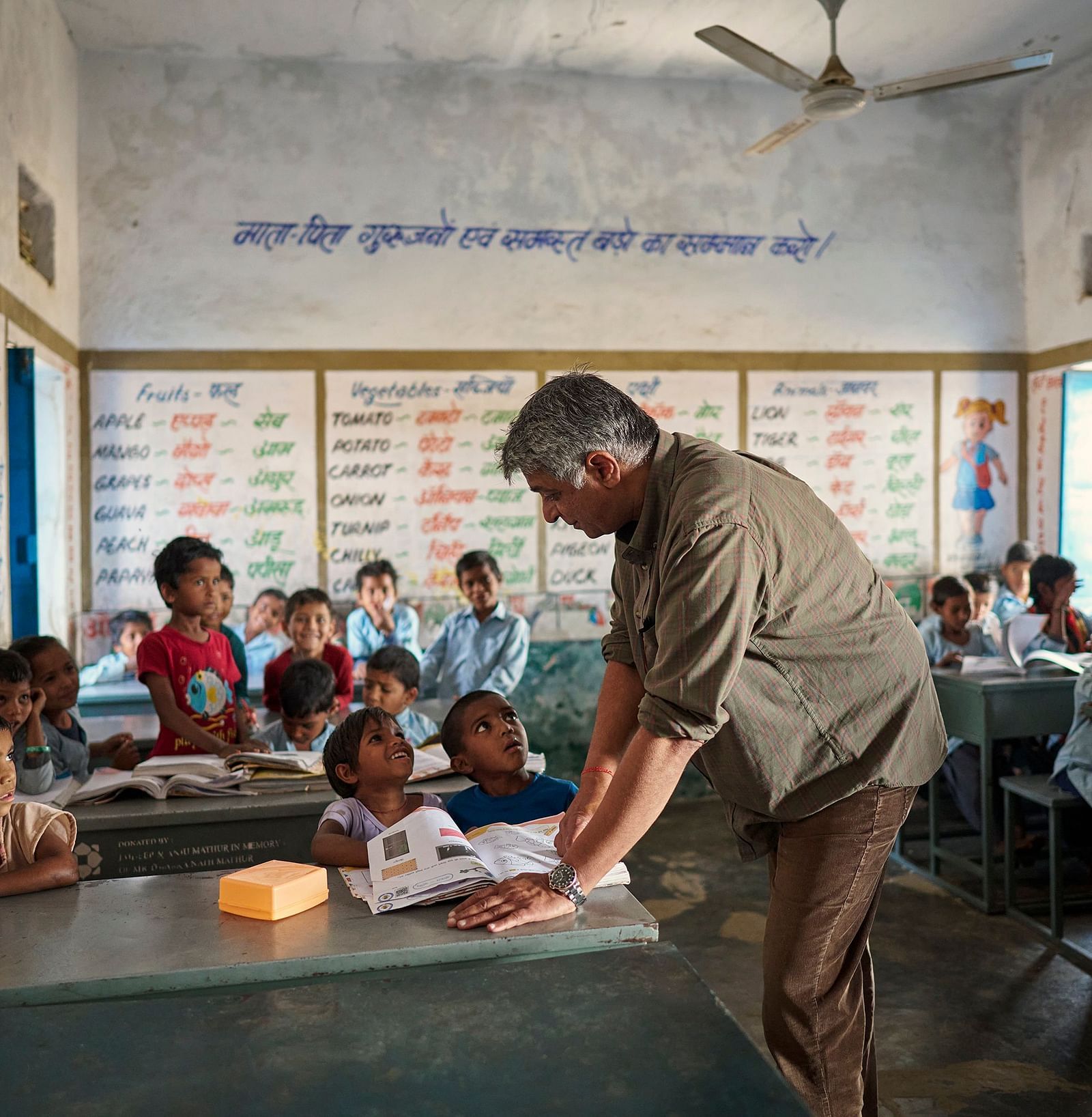 image of an old man teaching students in a government school at deogarh