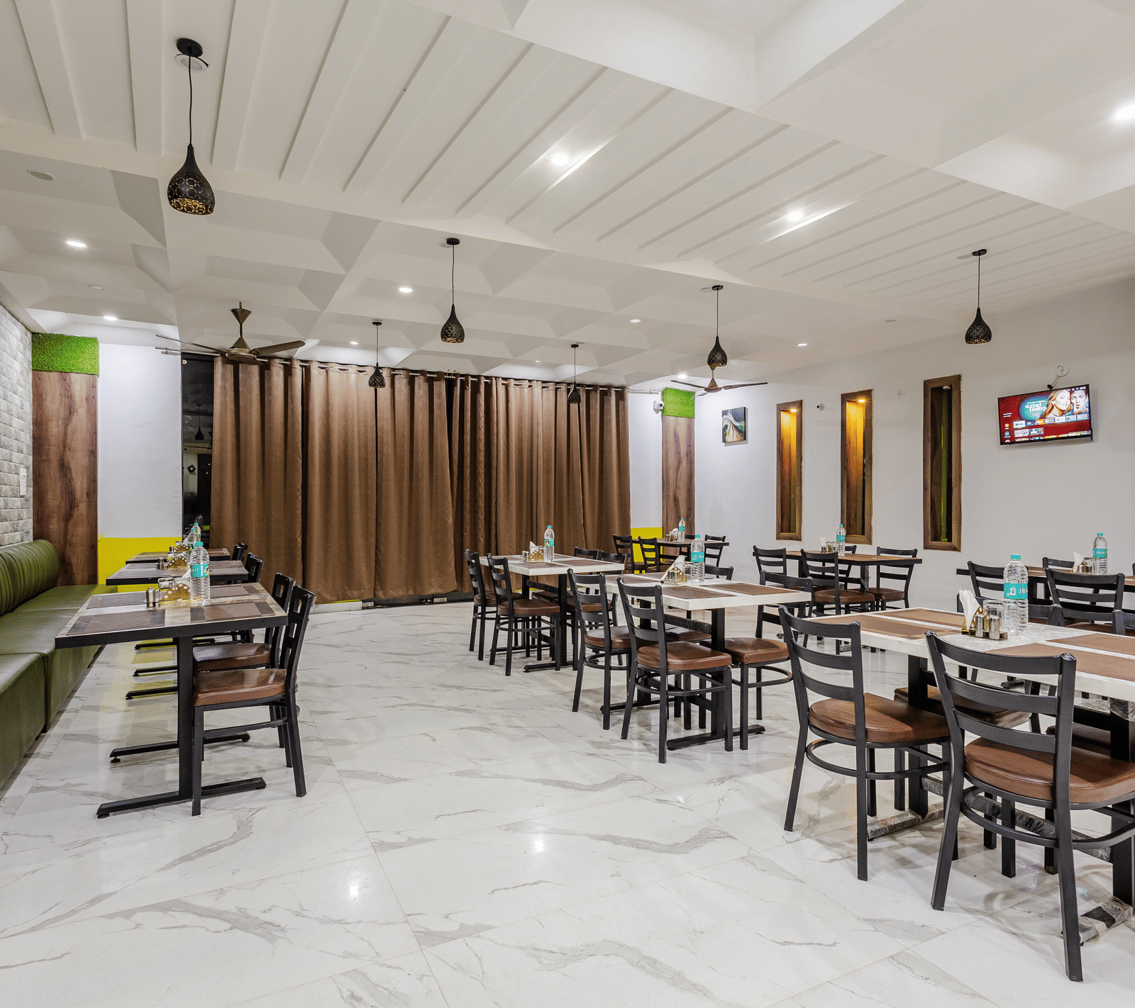 The indoor restaurant at Lime Tree Hotels and Banquet, Vrindavan with well defined seating area.