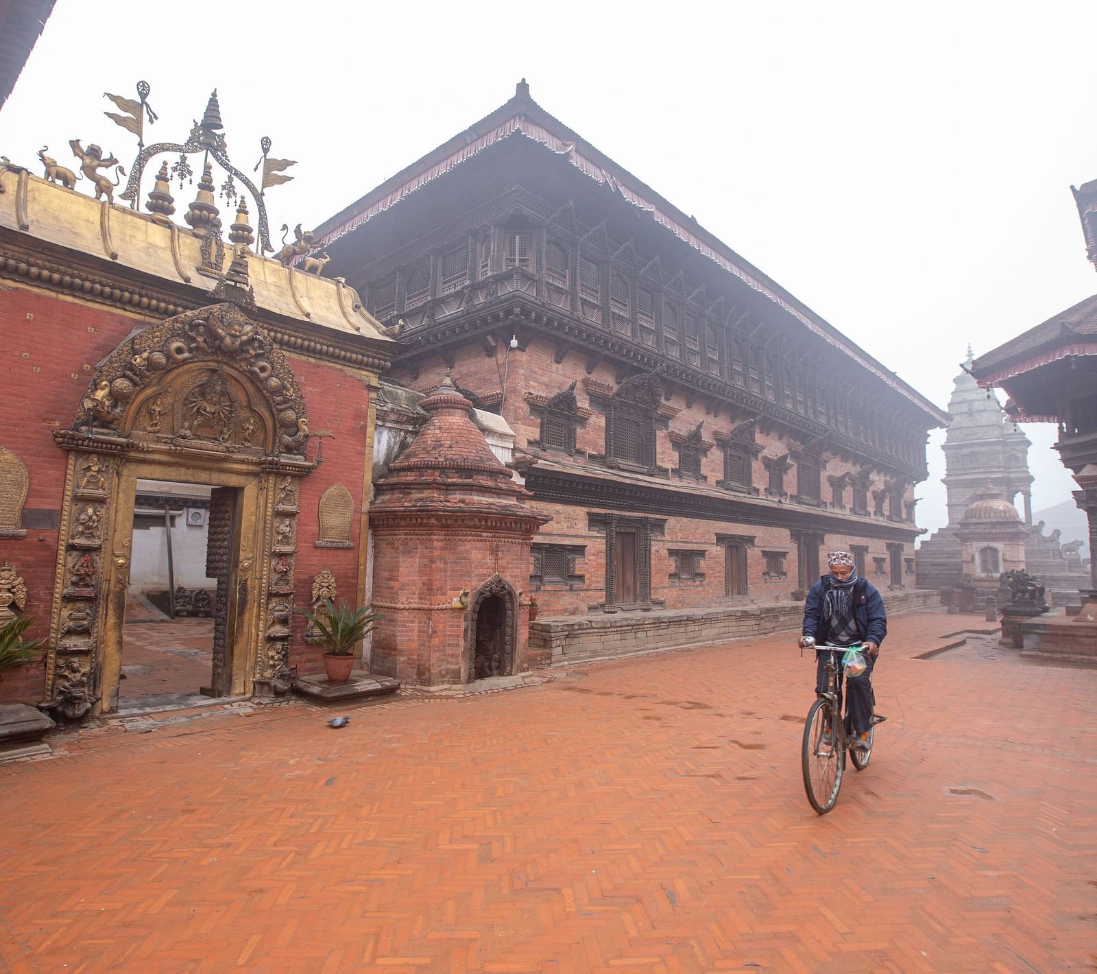 A facade view of the 55 window palace with golden gate in front of which a man is riding his bicycle