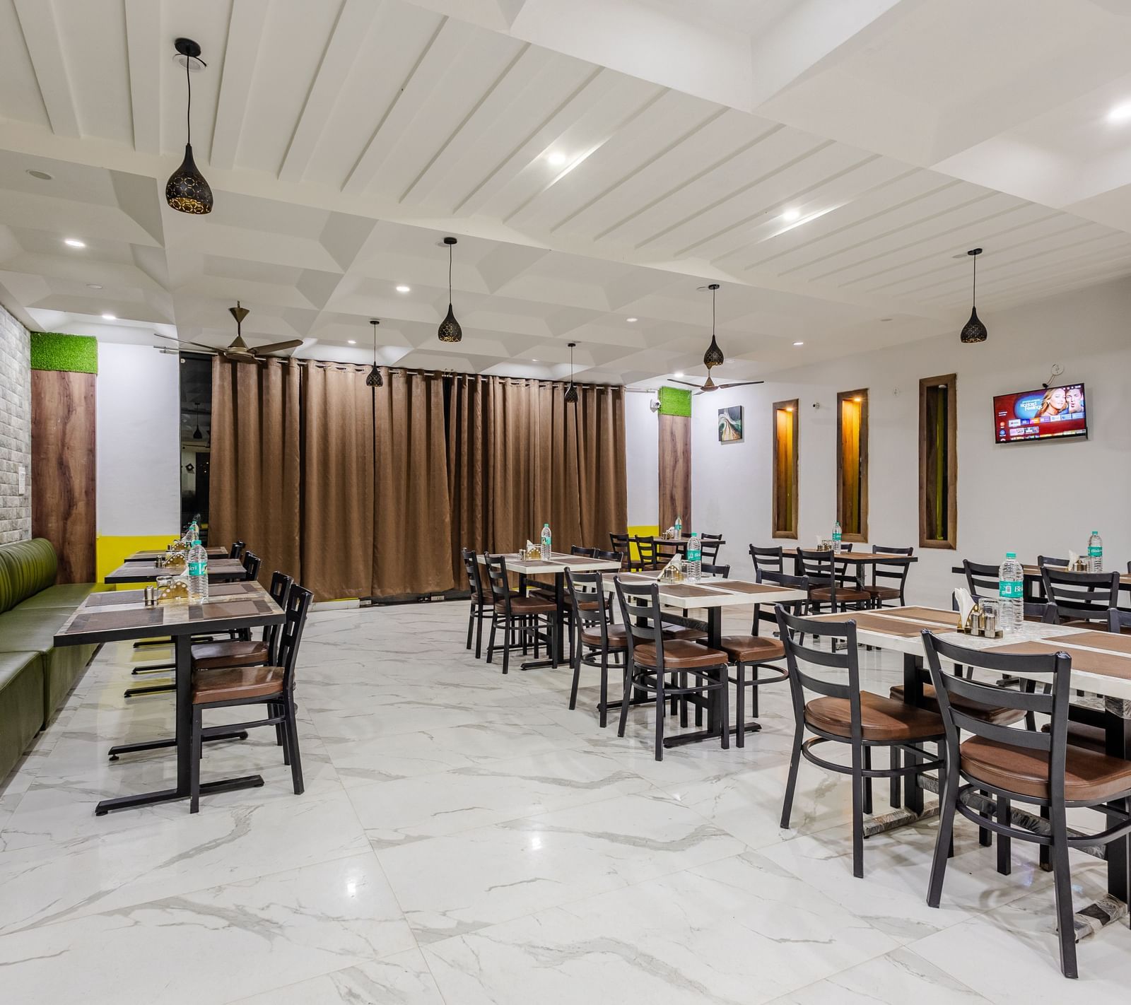 The indoor restaurant at Lime Tree Hotels and Banquet, Vrindavan with well defined seating area.