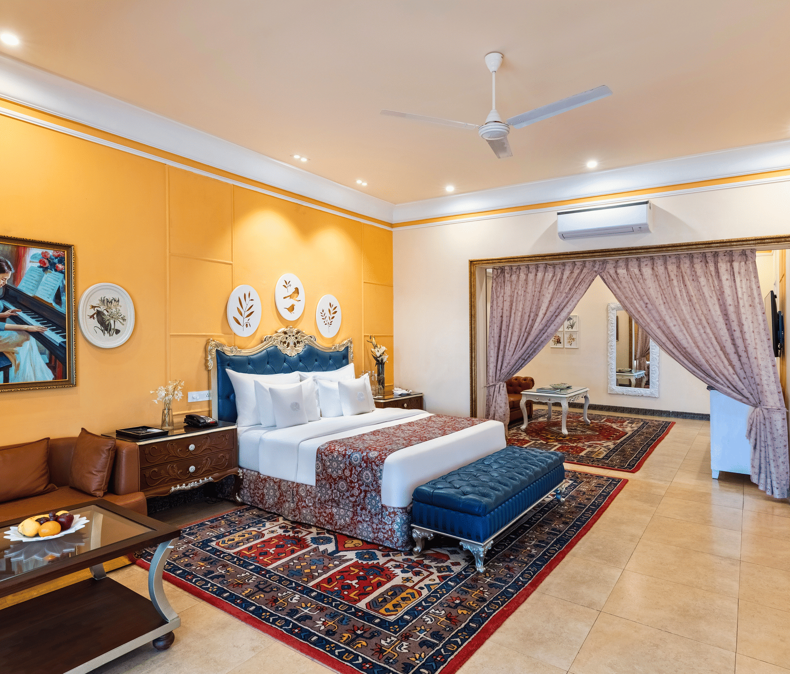 Family suite with a king bed, a seating area, a sofa, a coffee table and an adjoining room through an archway at MAYFAIR Palm Beach Resort, Gopalpur-on-Sea.