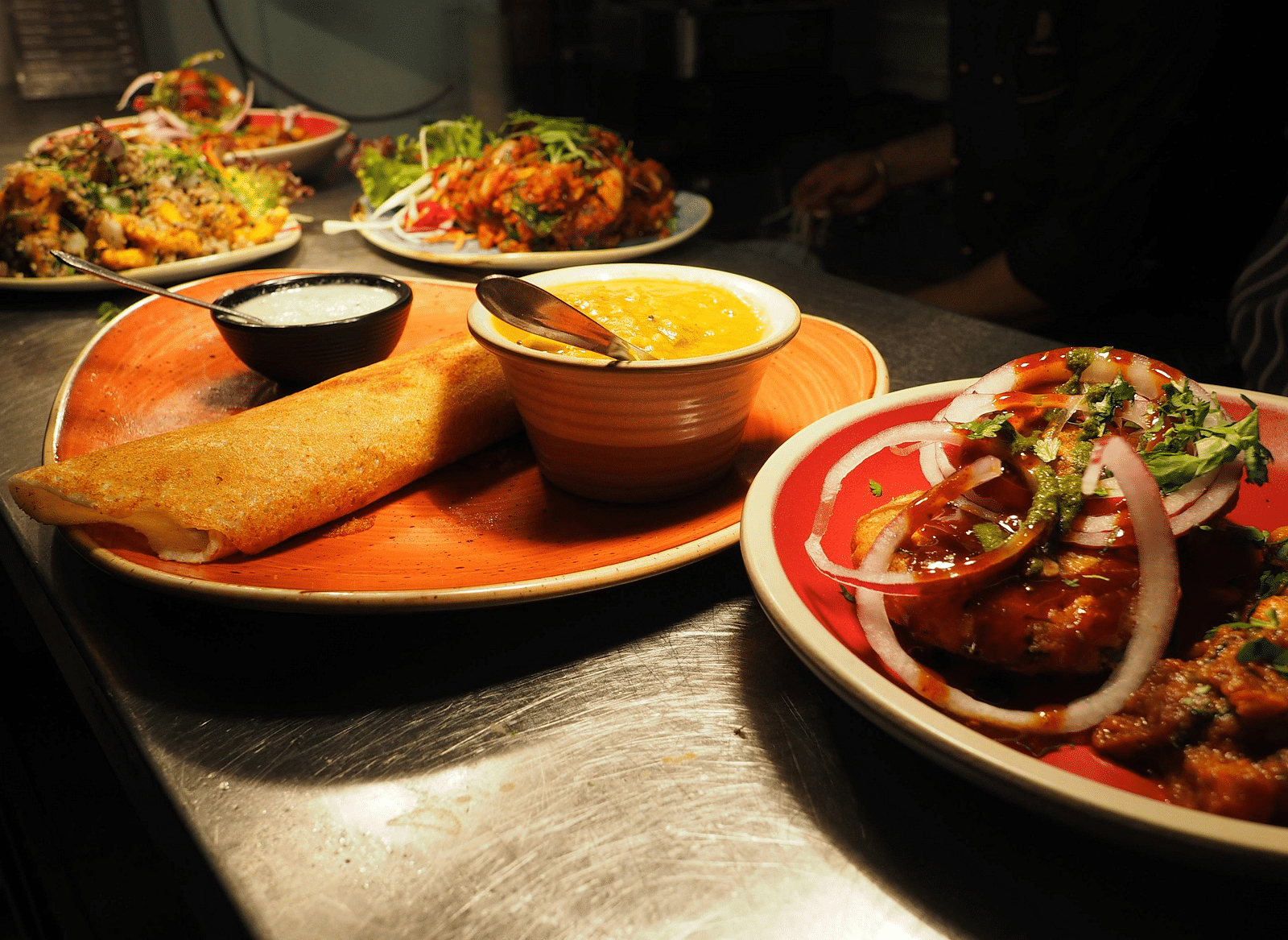 South Indian dishes placed on plates in a row.