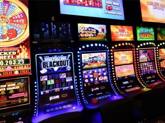 Brightly lit slot machines beckon with various games, a thrilling entertainment option at the Tallman Hotel.