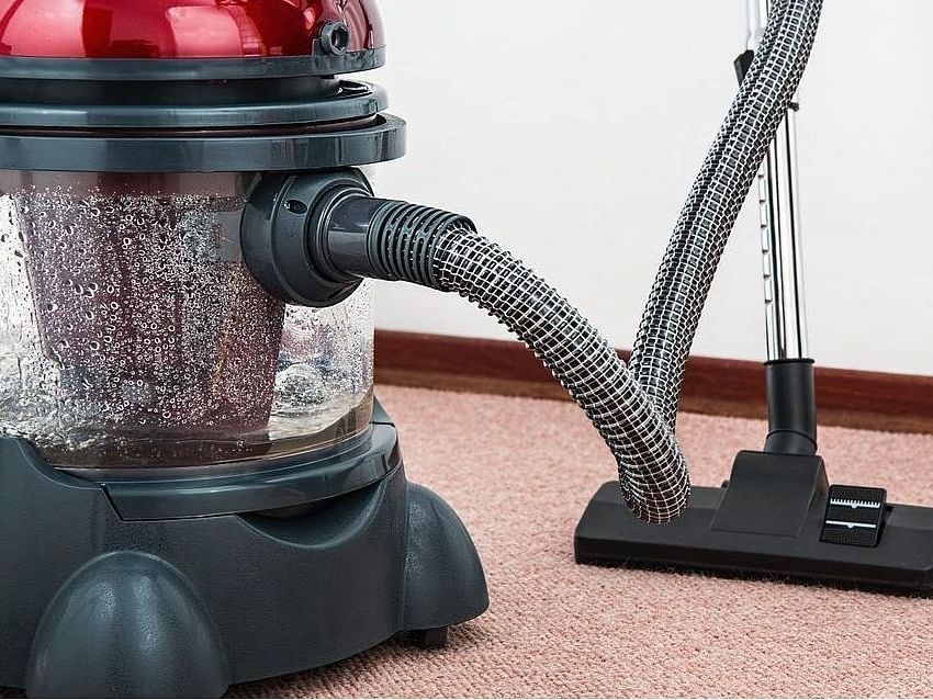 An image showing vaccum cleaner vaccuming the floor.