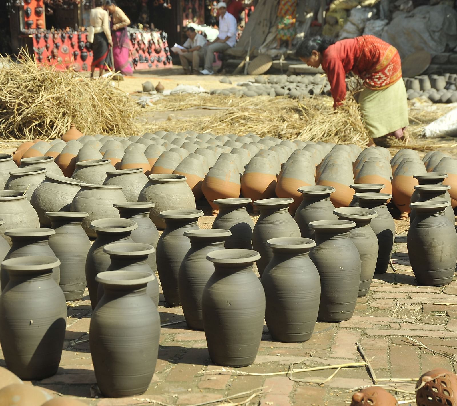 A pottery lined up on a ground which are kept for drying under the sun