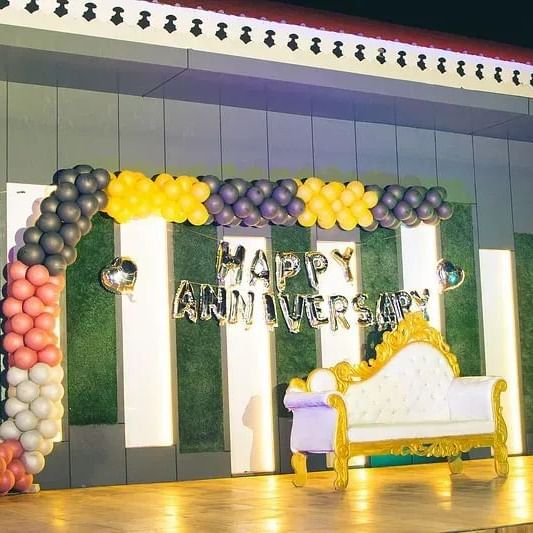A well-lit stage setup with colourful backdrops for an event at Daksh Resort and Amusement Park.