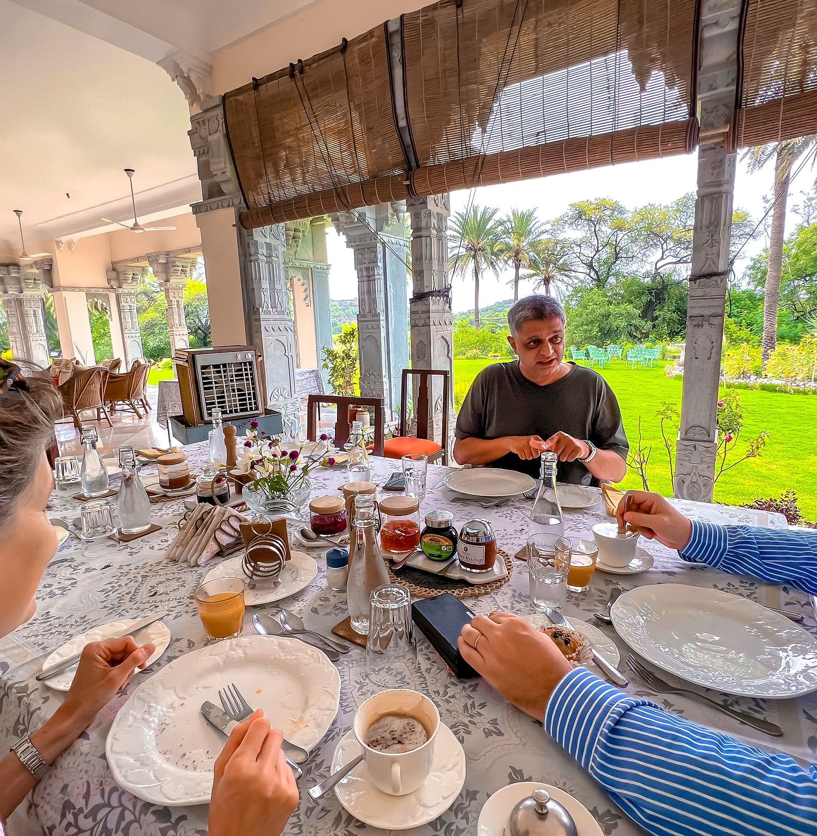 image of a group of three people having brunch at Dev Shree, Deogarh overlooking a lush green lawn
