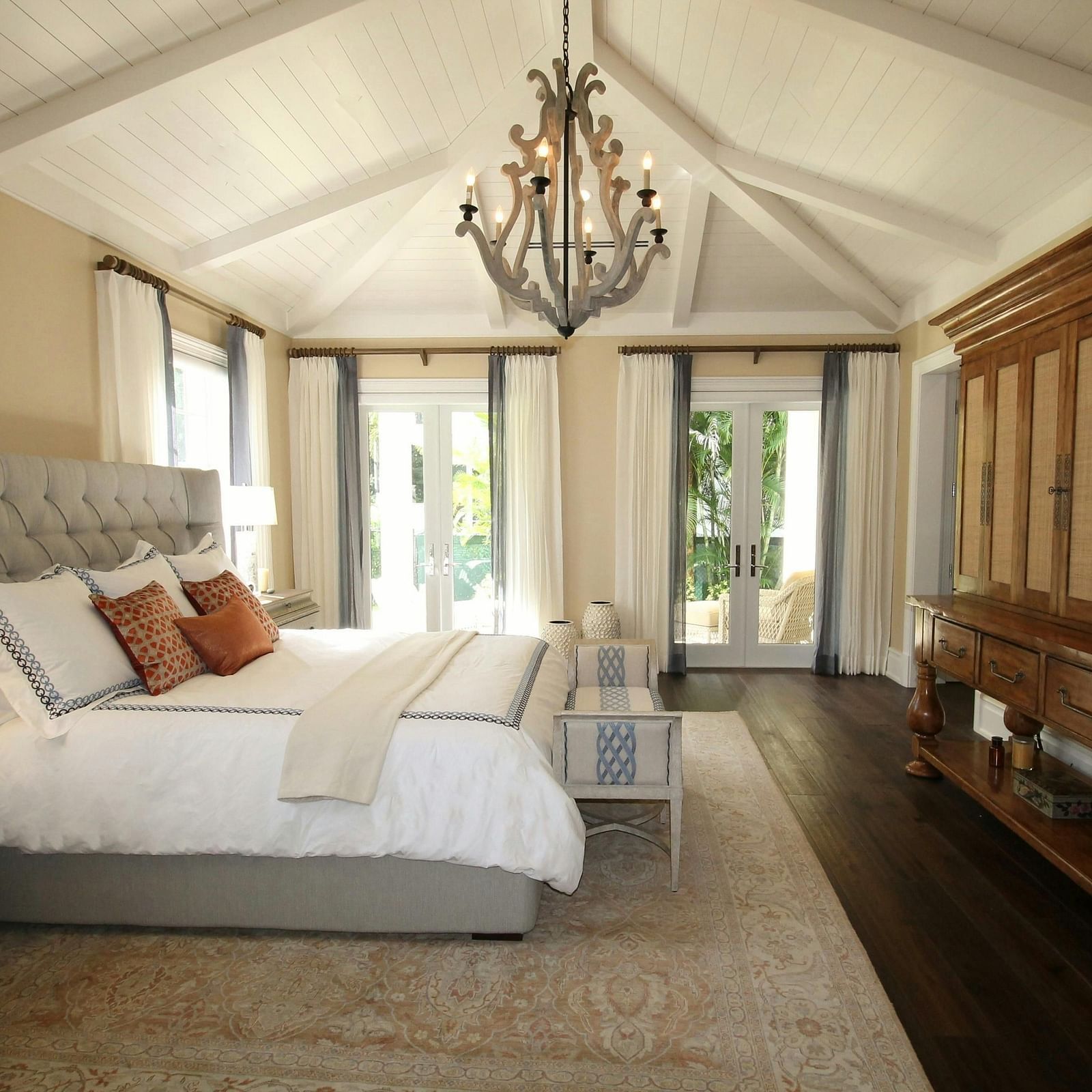 Side view image of a bedroom with a double bed in the middle with a chandelier hanging from the ceiling at Eminence The Corbett