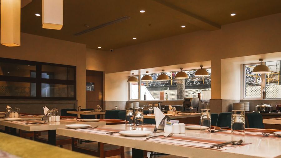 An inviting restaurant interior with neatly set tables and elegant lighting, ready for diners at Shilton Dee Cee.