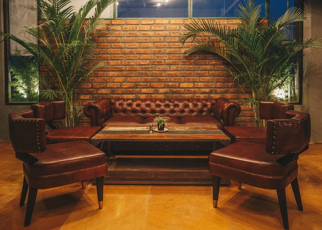 A comfortable leather couch with two cushioned armchairs in front of it along with a centre table in the middle.