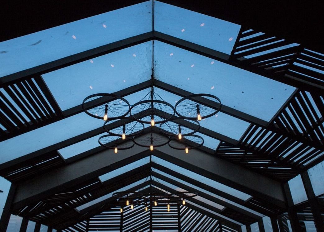 The ceiling at the To Be Continued Sky Lounge with a modern chandelier hanging to the glass ceiling.
