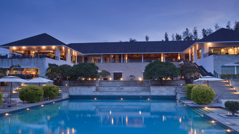 An image of the exterior facade of The Serai Chikmagalur in the evening.