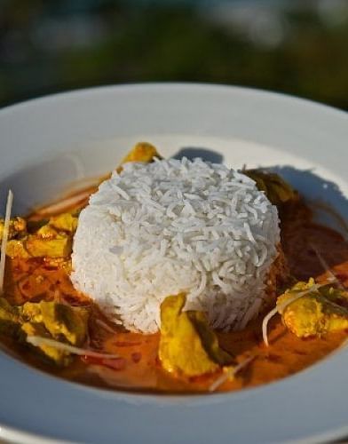 Plate of white rice and curry with vegetables, placed outdoors with blurred background | A Stone's Throw Away