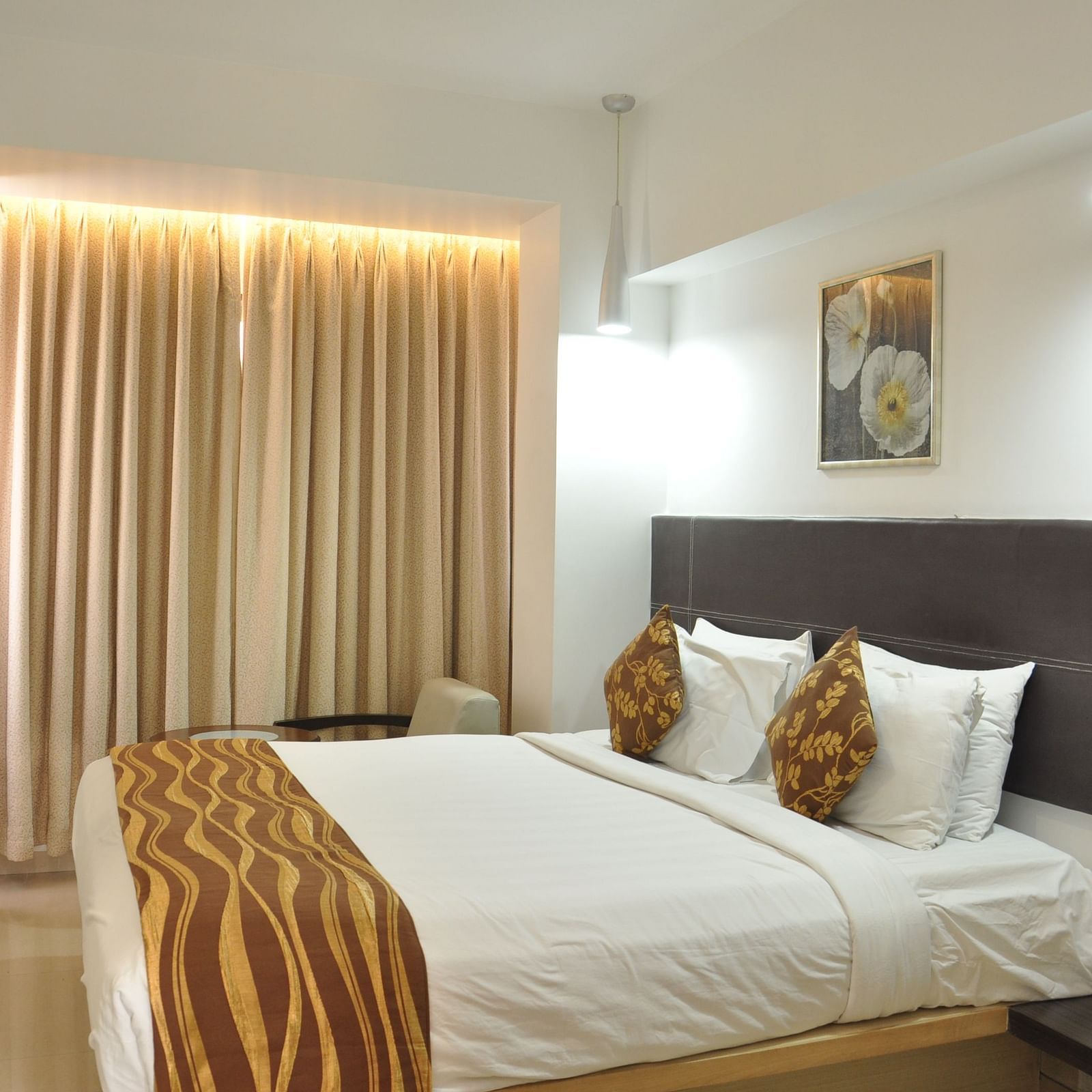 Premuim King Room with bed and a television in front of it at The Oriental Residency