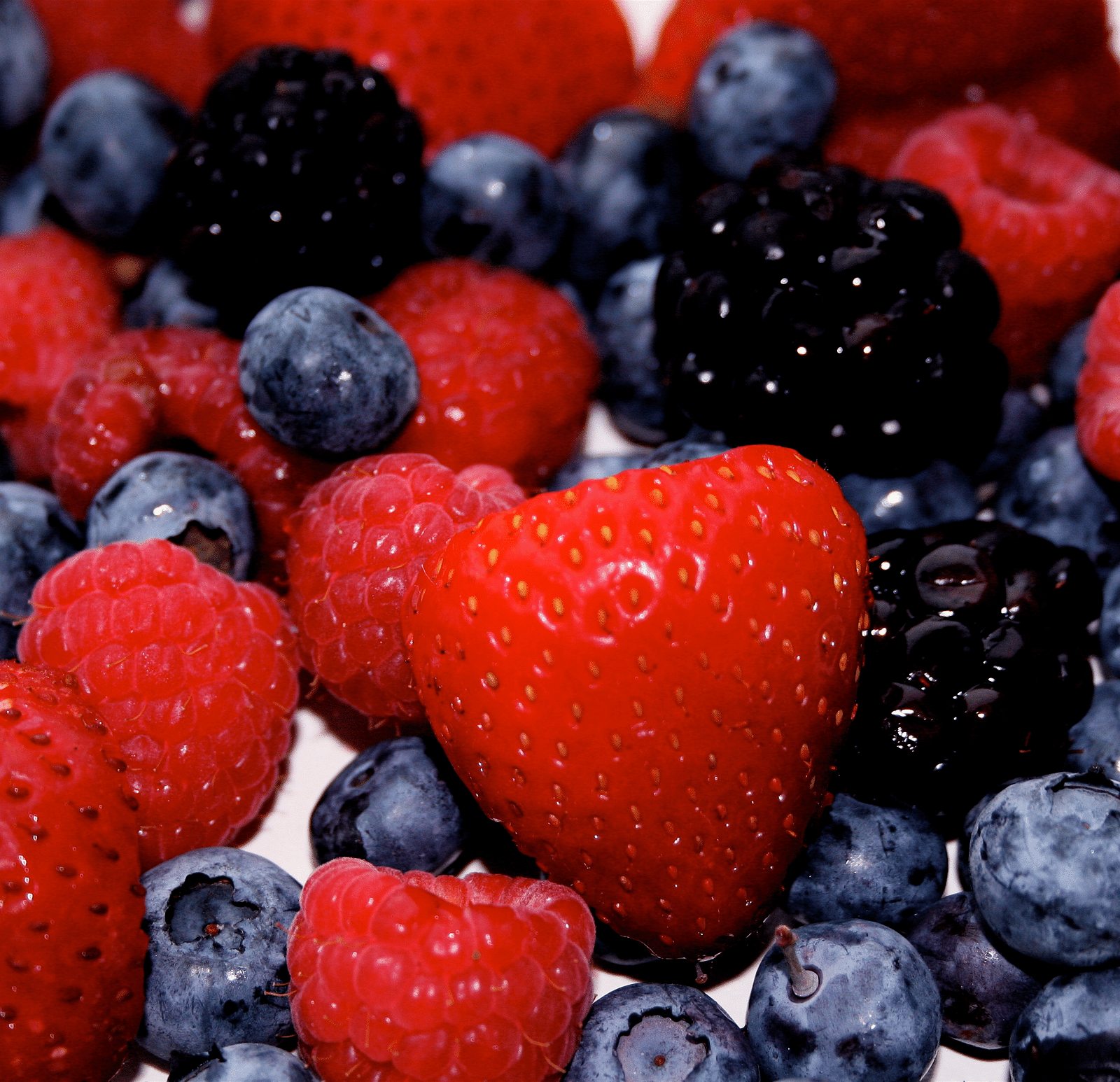 An close up  image  featuring strawberries, blueberries and blackberries.