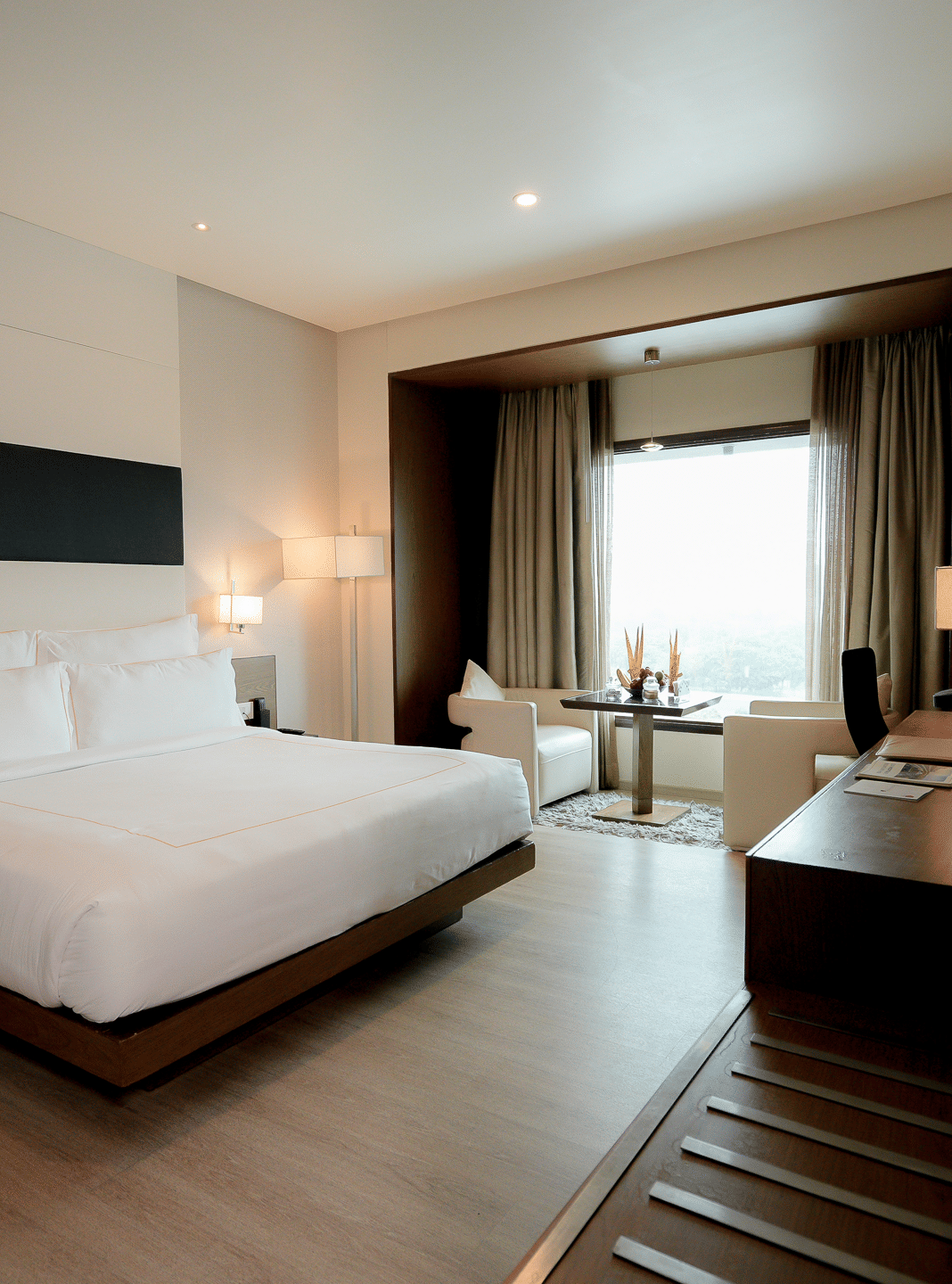 Spacious hotel room with modern furnishings and natural lighting – Narayani Heights Hotel & Resorts