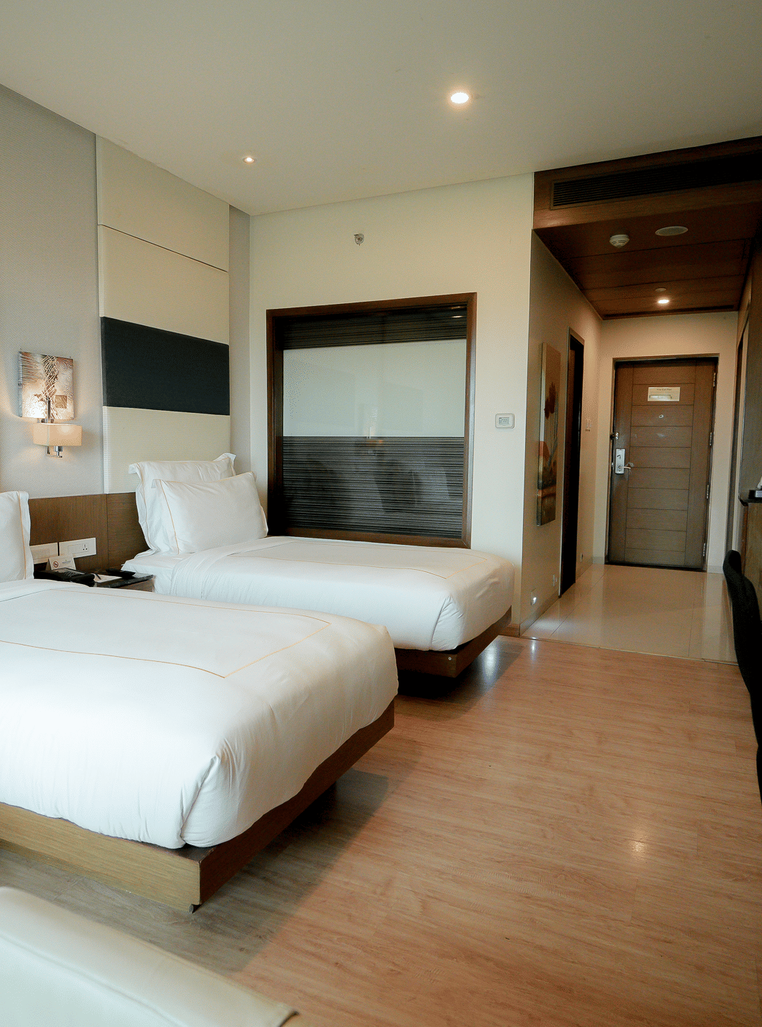 Spacious hotel room with plush twin beds and a work area – Narayani Heights Hotel & Resorts