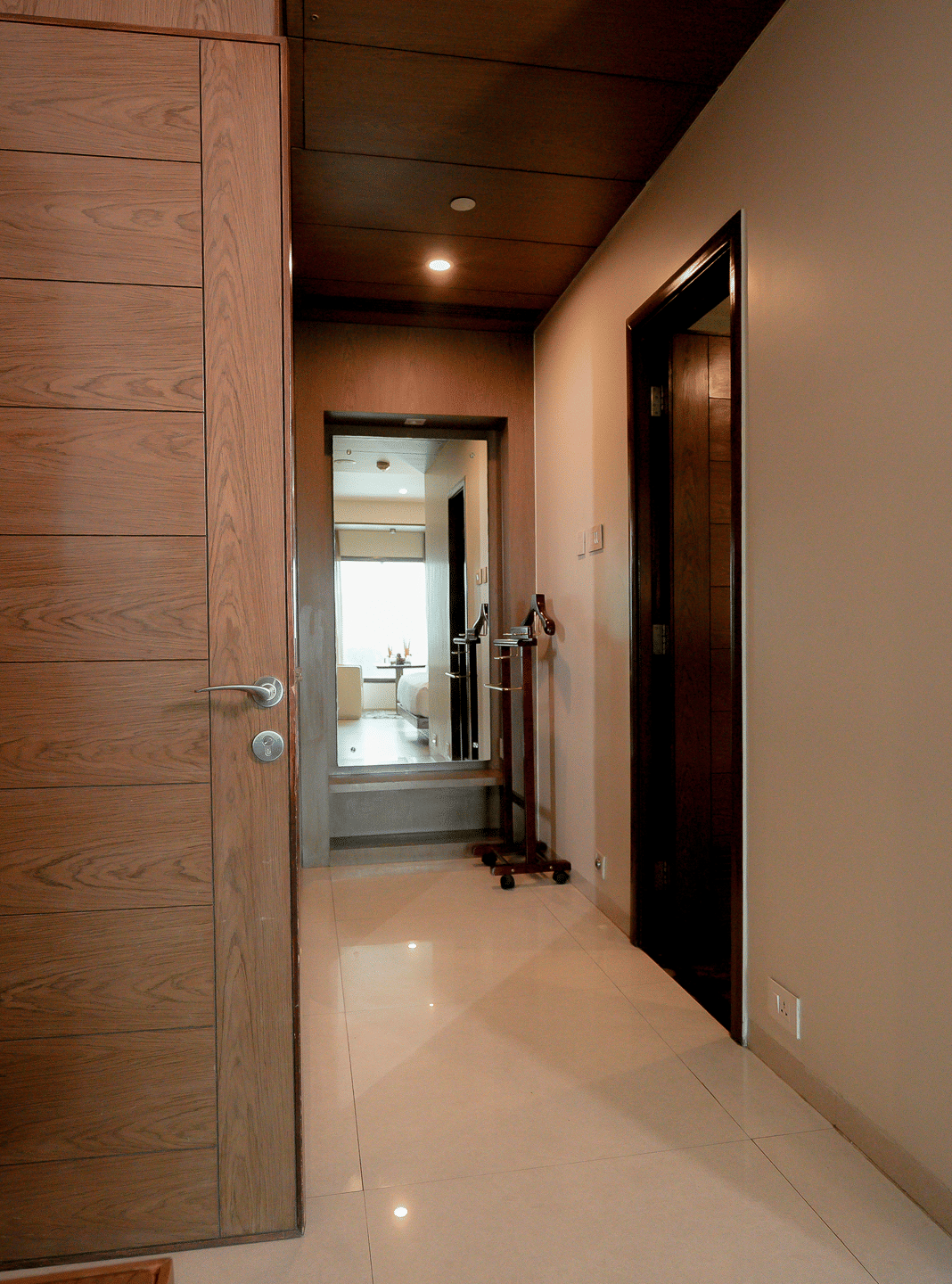Hotel corridor leading to rooms with polished flooring and warm lighting - Narayani Heights Hotel & Resorts