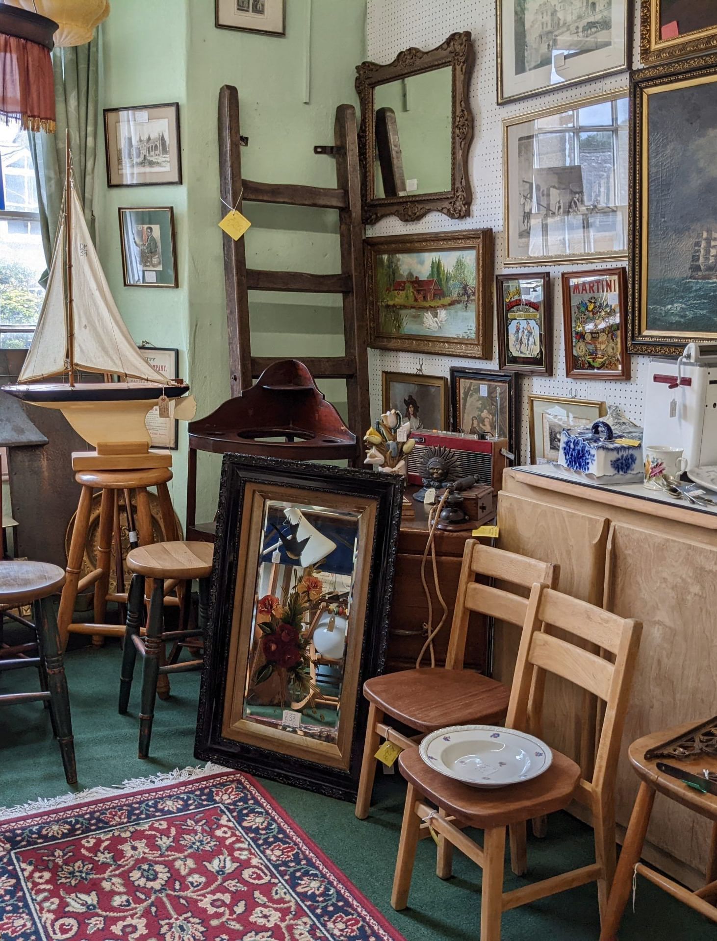 A room full of art supplies, stools, chairs, and many framed paintings in Tallman Hotel.