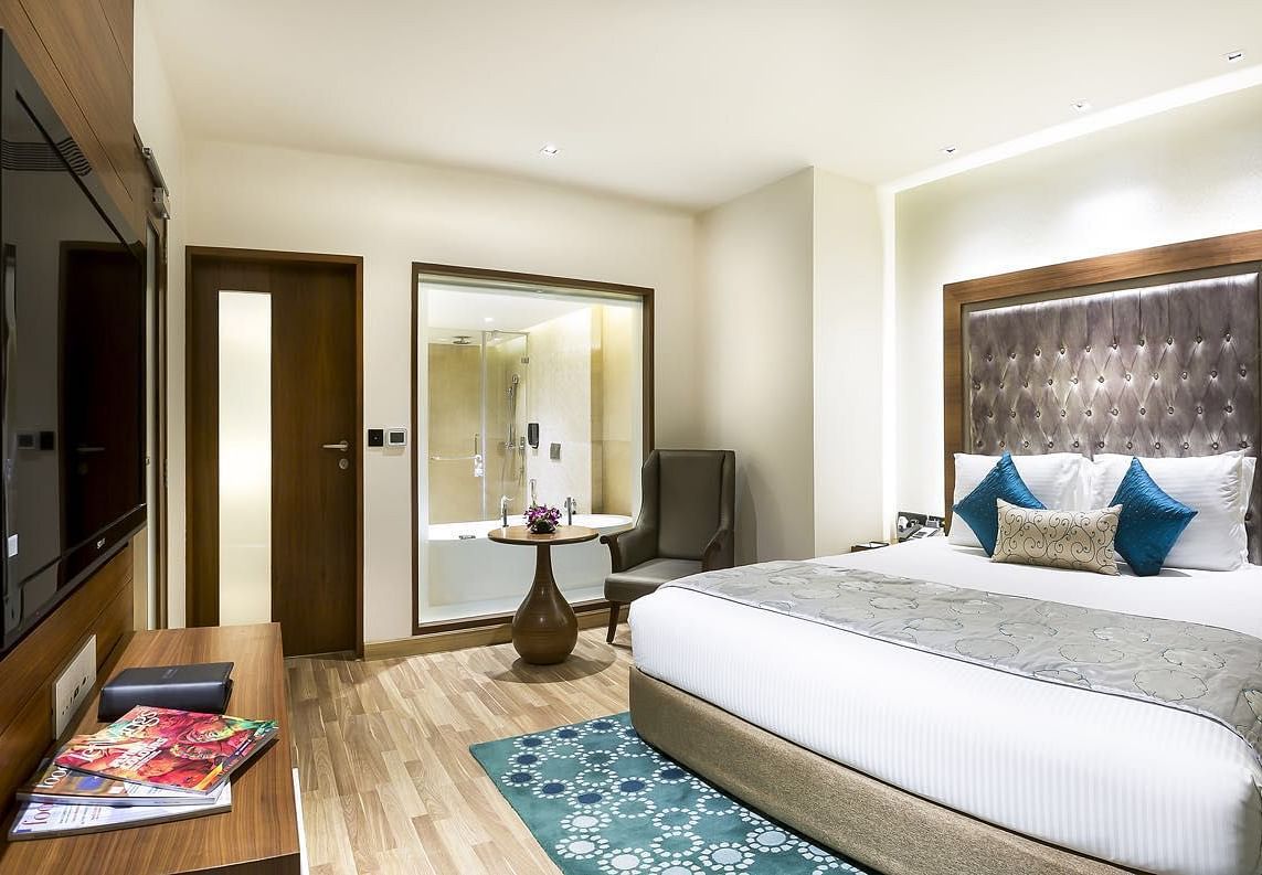 View of the king size bed of a Deluxe Suite at at Grand Chennai By GRT Hotels.