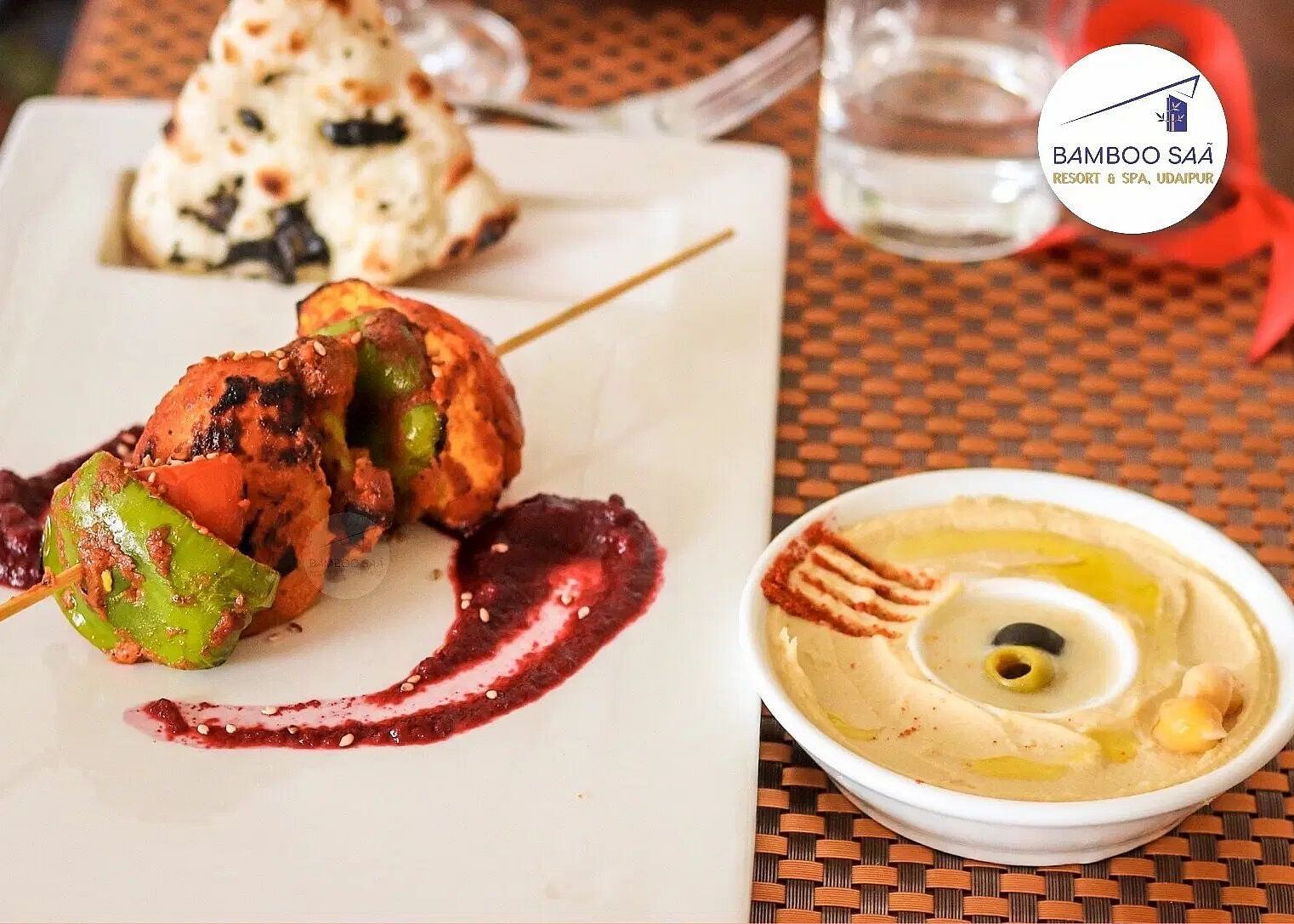 A flat lay of food on a table and a glass of water. - Bamboo Saa, Udaipur