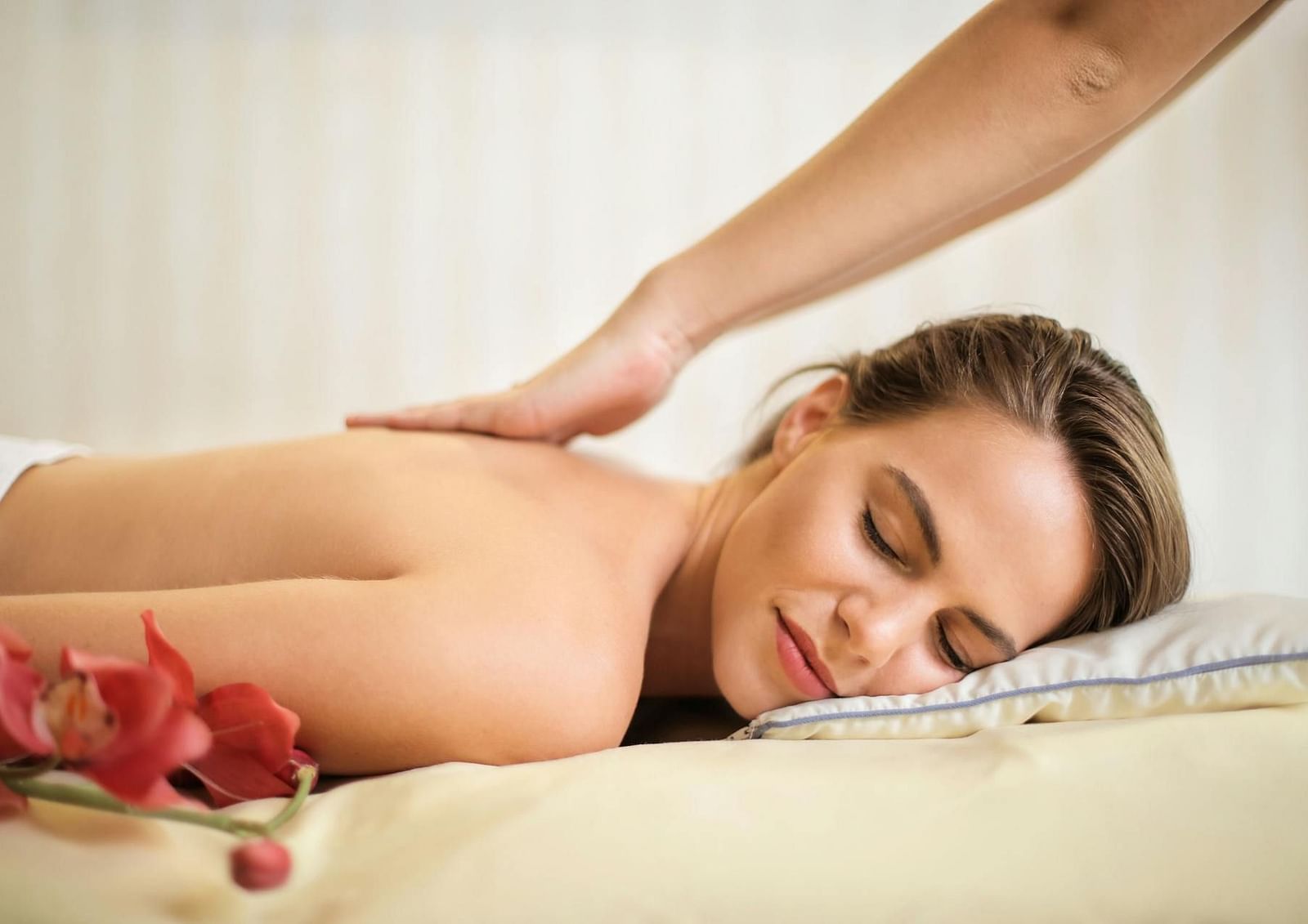 A woman enjoys a relaxing back massage in a soothing spa setting.