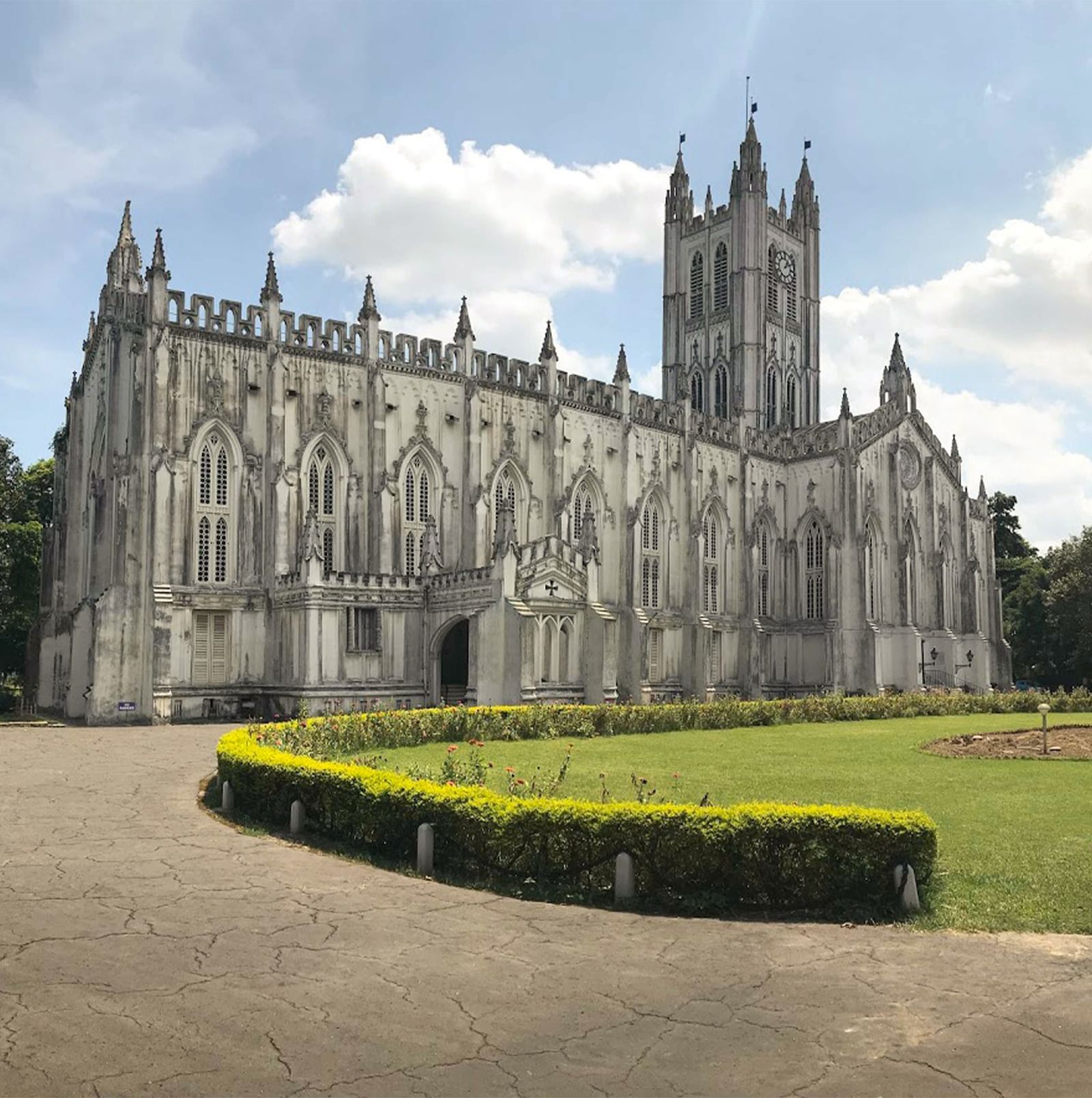 Large stone church with a green lawn and partly cloudy sky in the background.