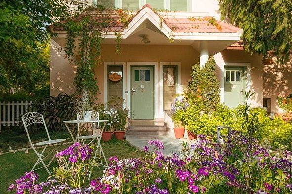 Small house-style building with chairs and flowers outside at Karma Chalets.