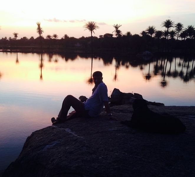 A person enjoying a sunset with his dog at dev shree, deograh