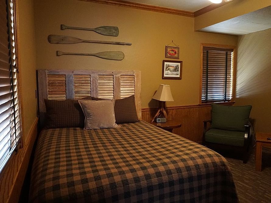 A room at Shaver Lake Village Hotel with a double bed and wooden oars hung on the wall behind it.