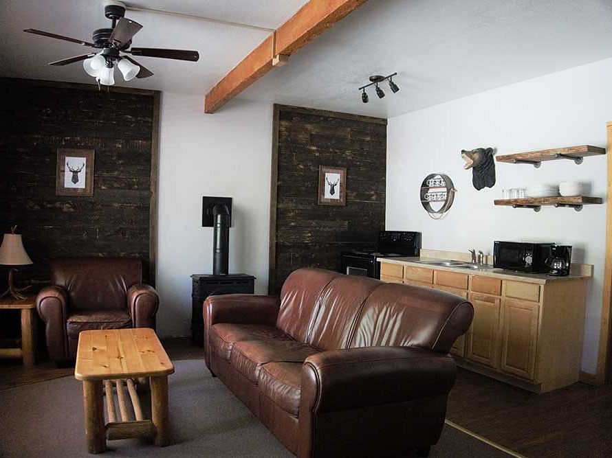 A room at Shaver Lake Village Hotel with a double sofa placed in the center of the room with a wooden coffee table placed in front of it.