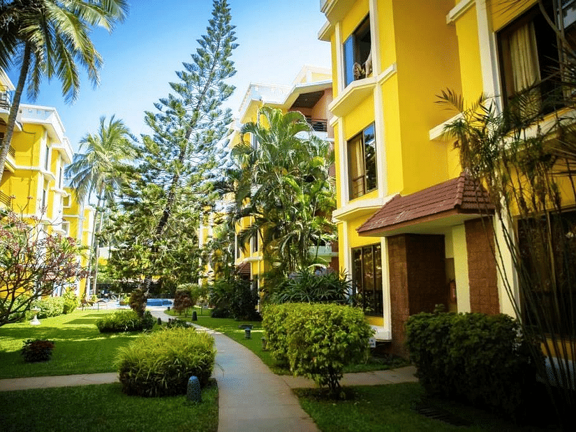 The exterior yellow facade of Adamo The Bellus, hotel in Goa