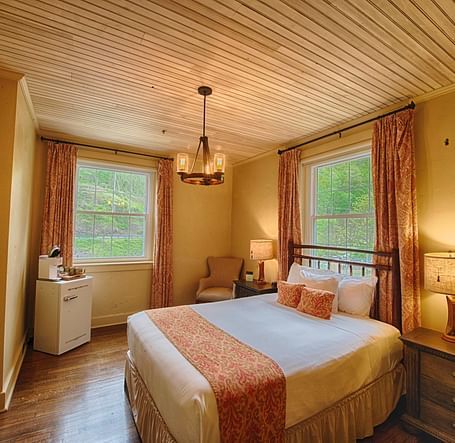full view image of a bedroom with two huge windows with open curtains - Historic Tapoco Lodge