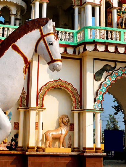A toy horse with moumental structured building in the backdrop.