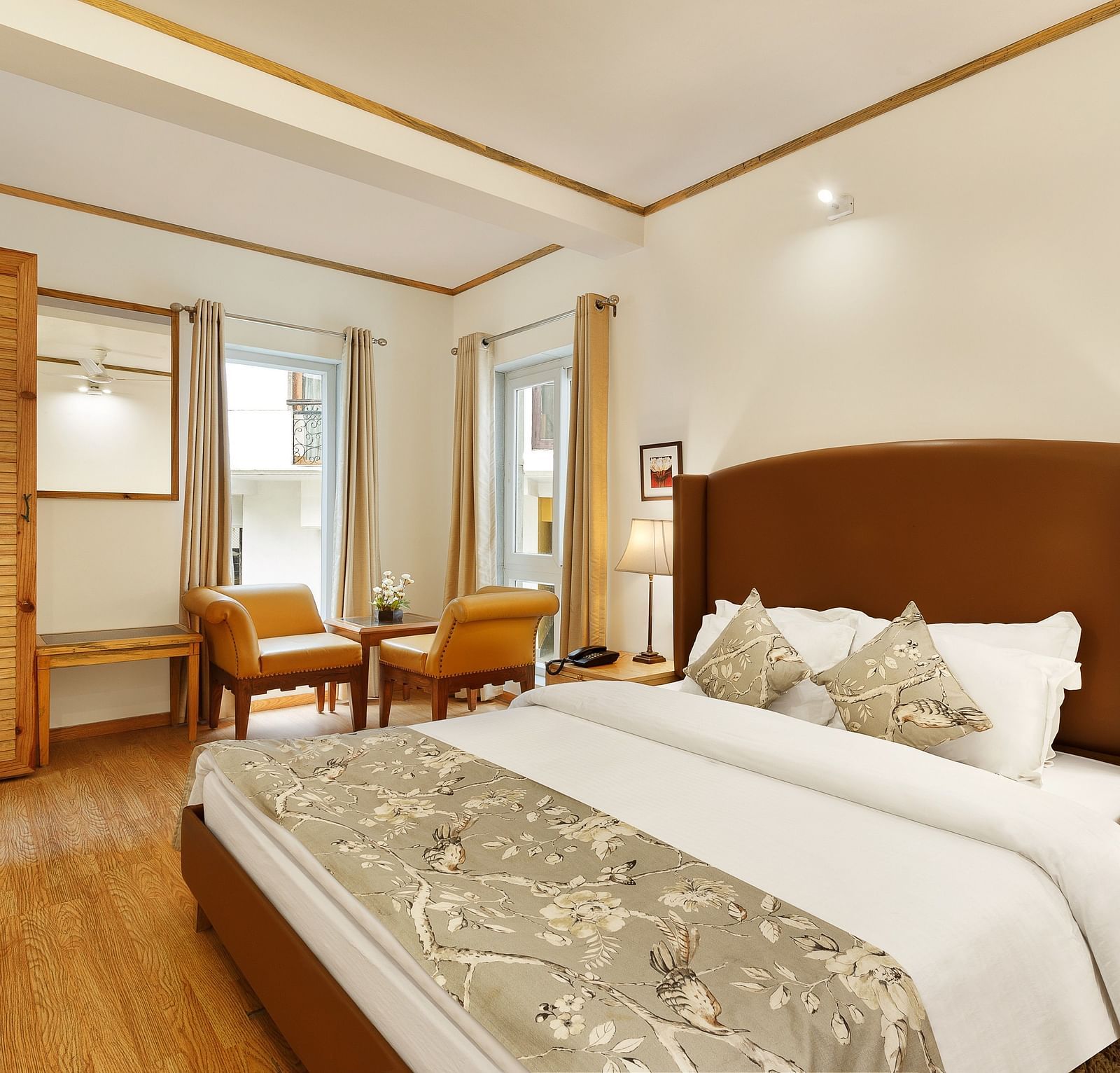 A cosy room with comfy bed chairs and a cupboard near window in Pinewood Nainital 