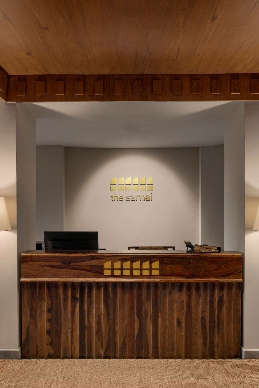 A reception desk with two lamps on either side of the desk - The Samai, Bhimtal