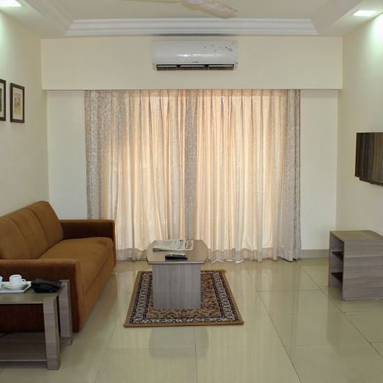  A living room featuring a tv, a sofa, a table and wall paintings - Maxxvalue Apartment Marol