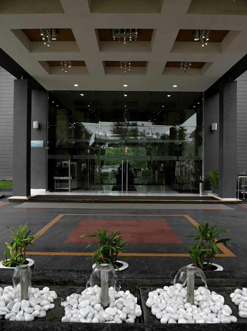 Entrance of the hotel with landscaped garden at Narayani Heights Hotel & Resorts, Ahmedabad.