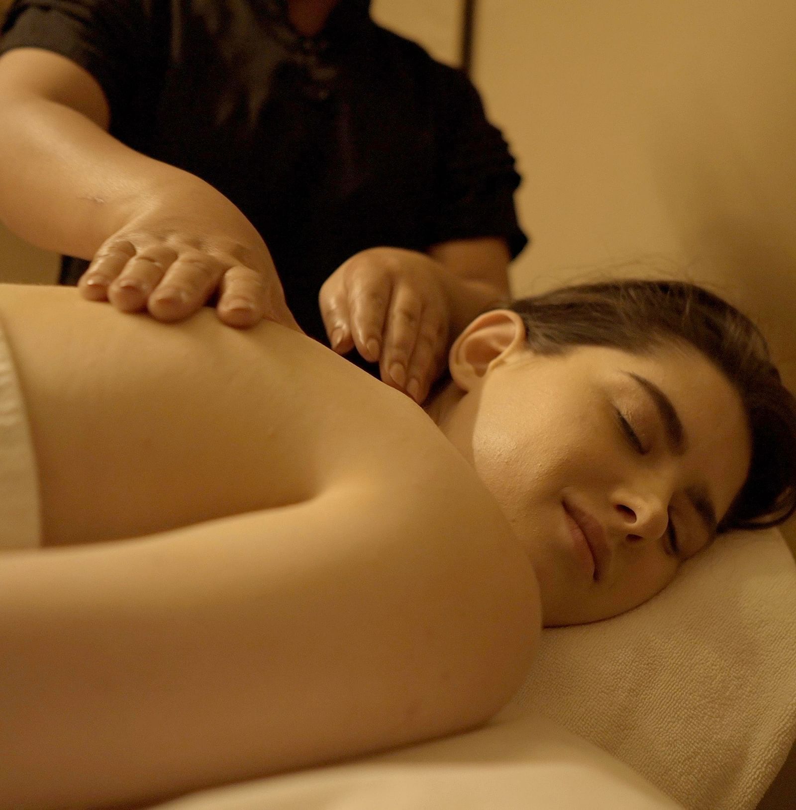 A masseuse providing a back massage to one of our guests at our Spa near Hairdwar - Aalia Jungle Resort & Spa