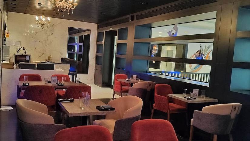  Café-style seating area with compact tables, decorative shelving, and open layout.